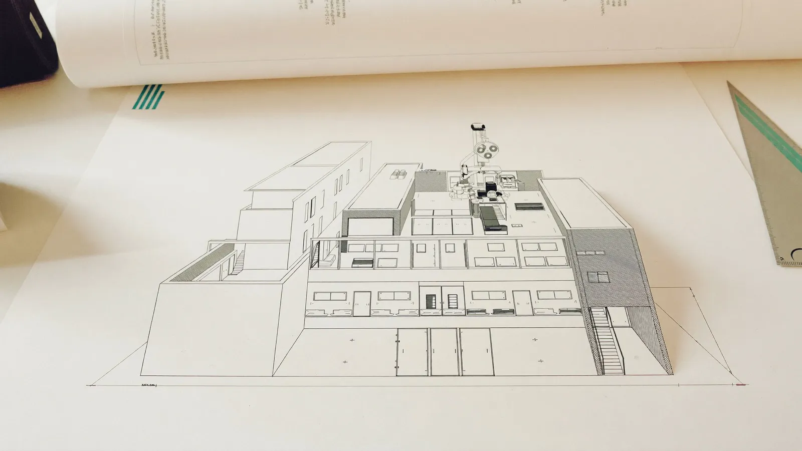 Corte arquitectónico de una clínica de tres niveles sobre el restirador, con vestíbulo a doble altura, consultorios y el piso quirúrgico con su plenum de instalaciones